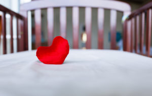 Heart in baby's crib. (child care concept)