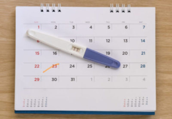 Pregnancy test on calendar background. Pregnancy care concept.