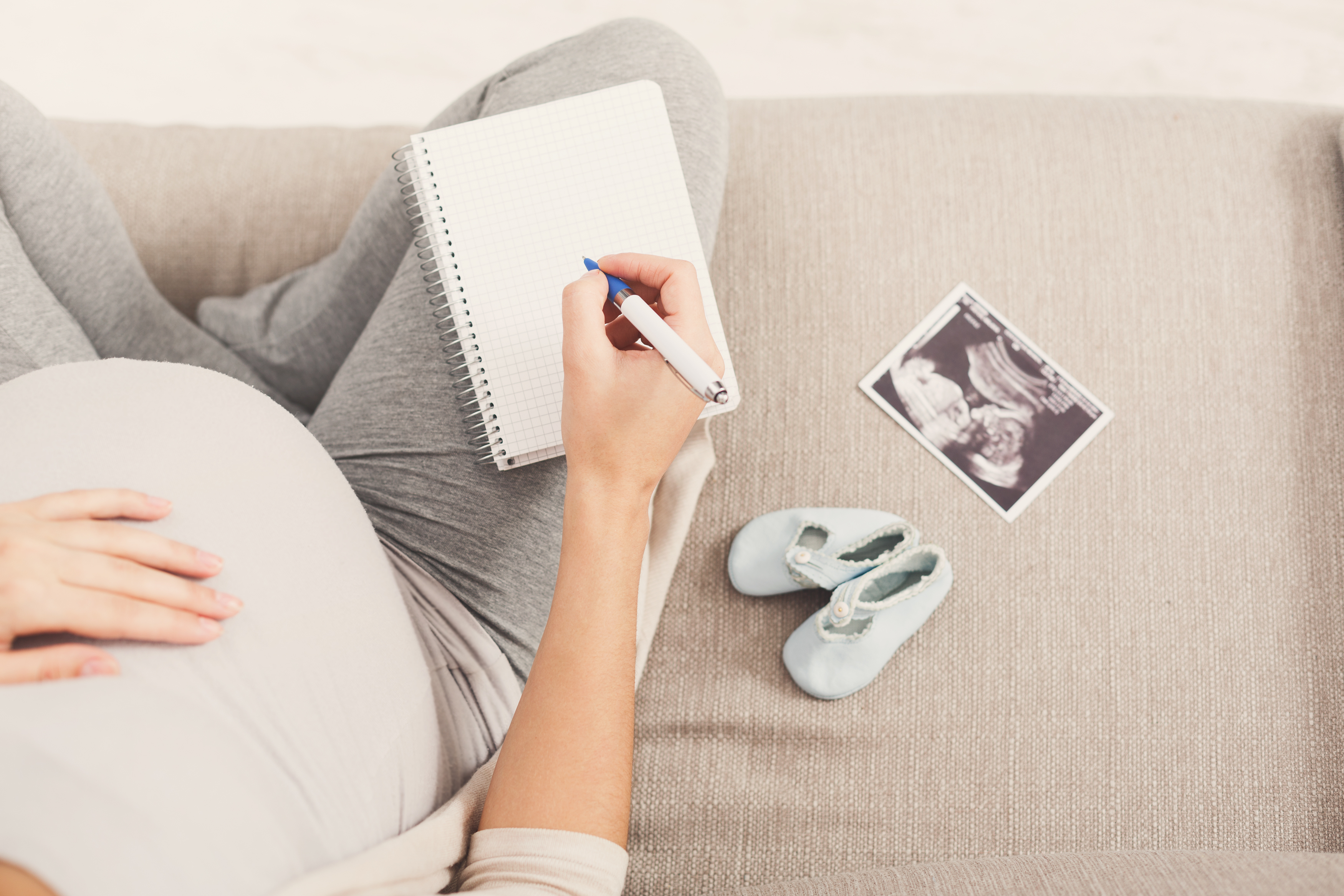 Pregnant woman writing names for her baby