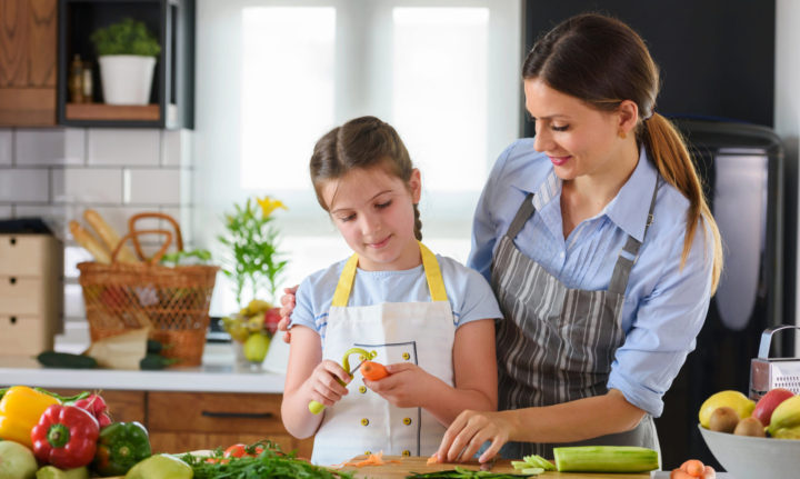 Mother Teaching Child to Cook and Help in the Kitchen. Mother and Daughter